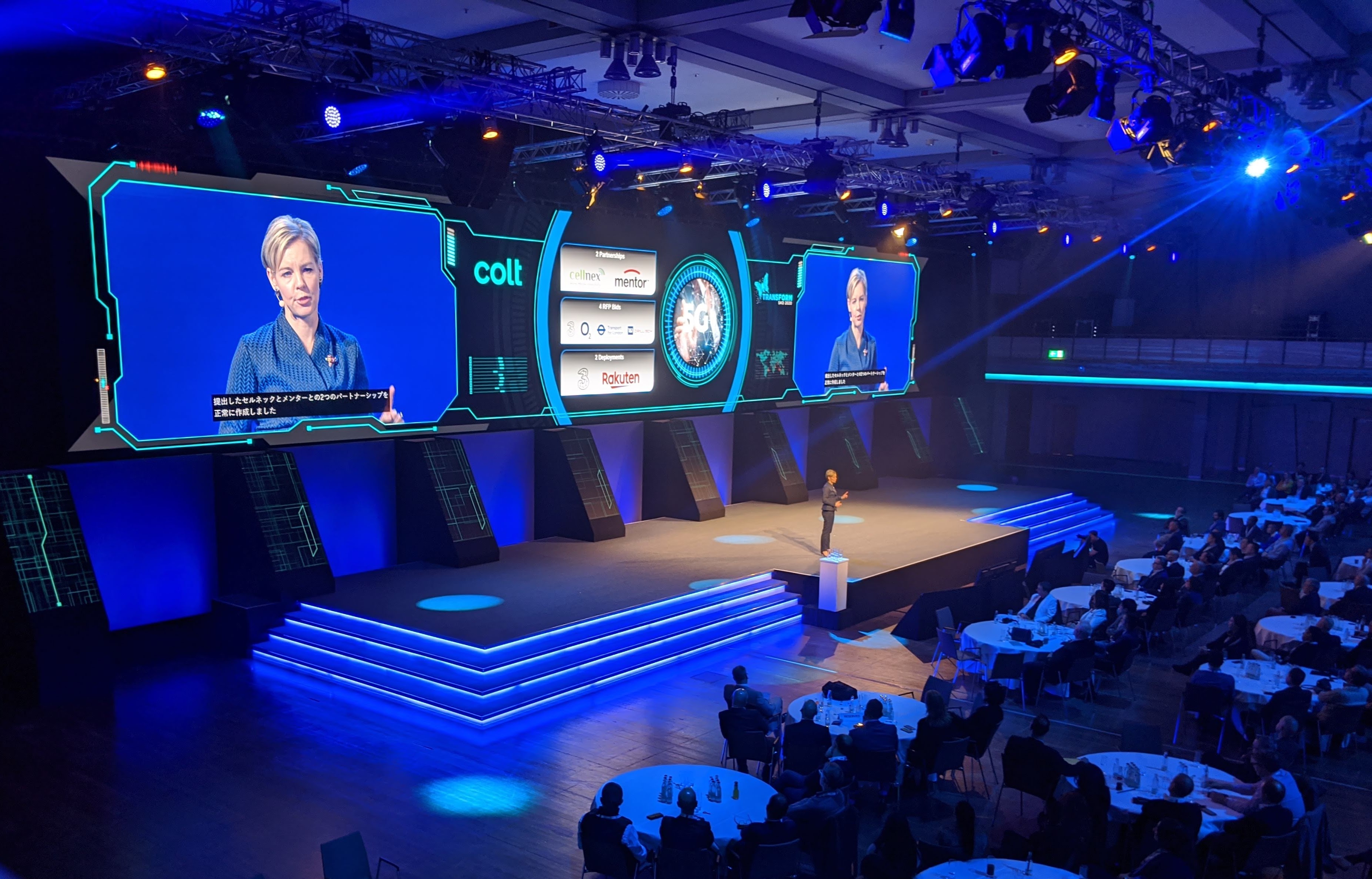 Colt corporate conference — wide LED screen array with speaker on stage