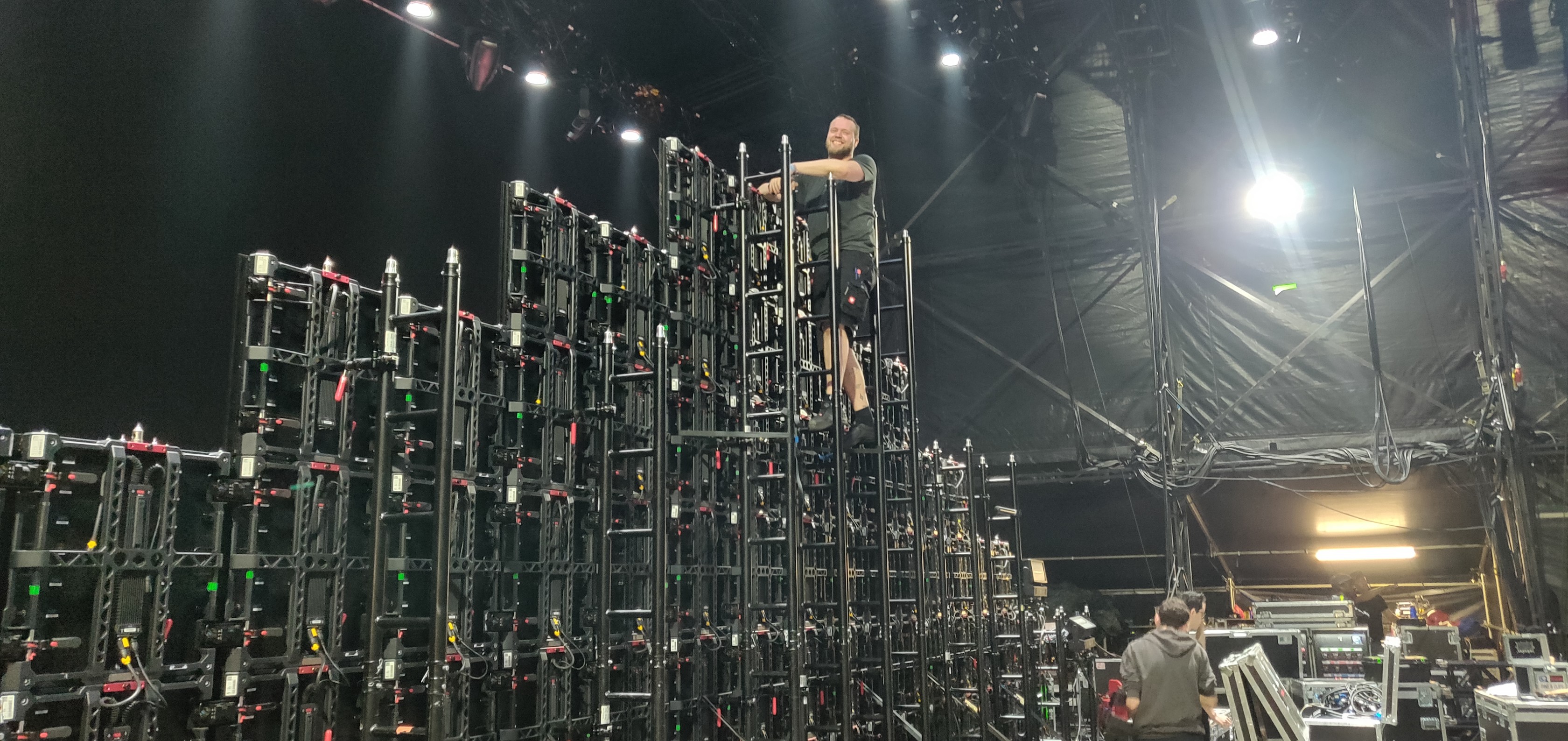 Technician working at height on LED wall structure during build