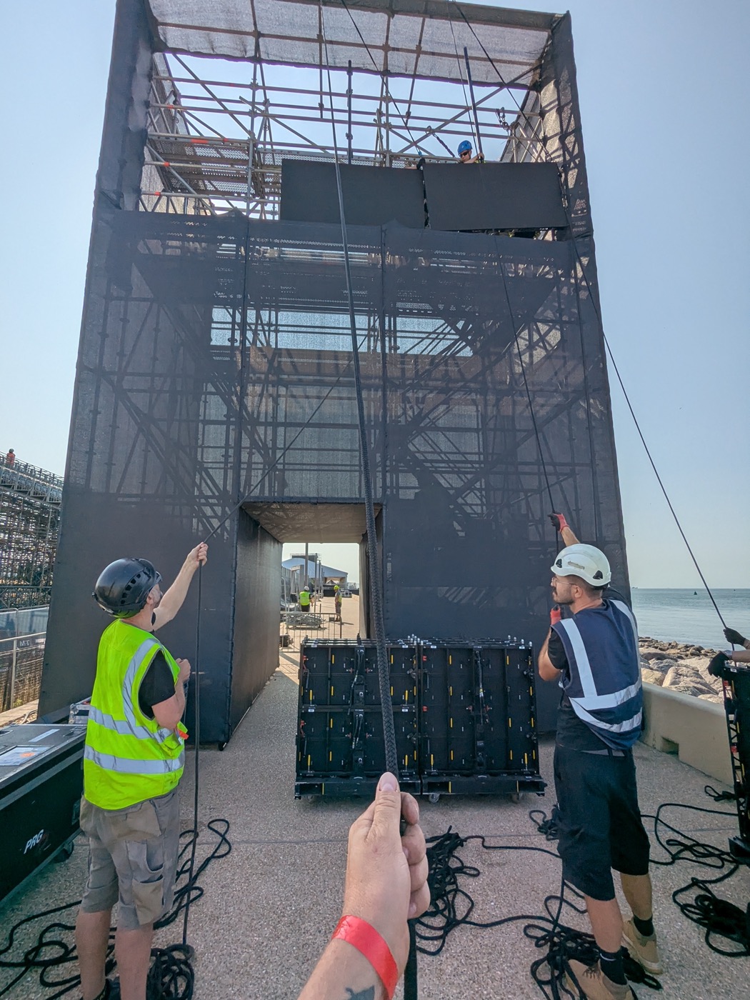 Crew flying LED panels into a scaffold tower